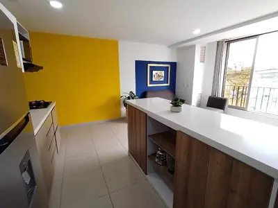 a kitchen with a white counter and a yellow wall at Frente al Malecón con Vista, Zona Gastronómica, PARQUEDERO GRATIS in Guatapé