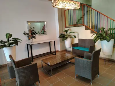 a living room with a table and chairs and a staircase at Frente al Malecón con Vista, Zona Gastronómica, PARQUEDERO GRATIS in Guatapé