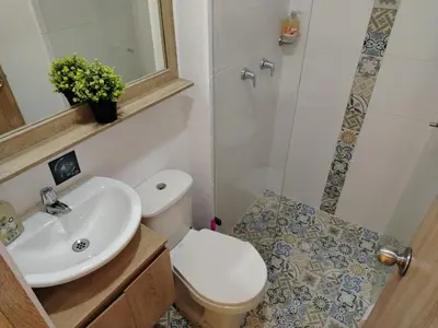 a bathroom with a toilet and a sink and a shower at Frente al Malecón con Vista, Zona Gastronómica, PARQUEDERO GRATIS in Guatapé