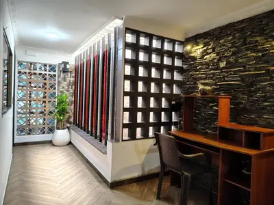 a room with a desk and a wall of wine bottles at Casa Hévenie, Amplia, familiar, cómoda y bien ubicada in El Poblado