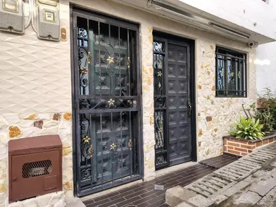 a house with black doors and a tv in front at Casa Hévenie, Amplia, familiar, cómoda y bien ubicada in El Poblado