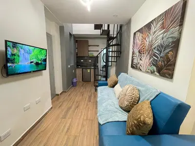 a living room with a blue couch and a flat screen tv at lindo apt la 70 Laurles estadio in Medellín