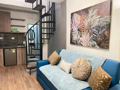 a blue couch in a living room with a staircase at lindo apt la 70 Laurles estadio in Medellín