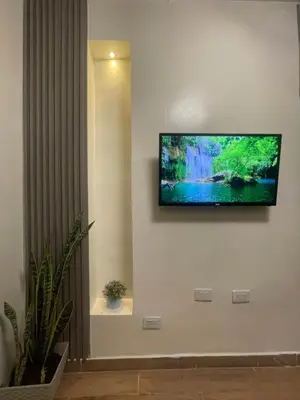 a flat screen tv hanging on a white wall at lindo apt la 70 Laurles estadio in Medellín