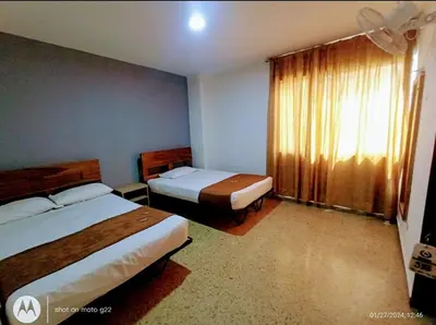 a hotel room with two beds and a window at Medellin Continental Hotel in Medellín