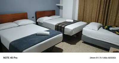 a hotel room with three beds with towels on them at Medellin Continental Hotel in Medellín