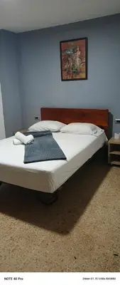 a bedroom with a large bed with white sheets at Medellin Continental Hotel in Medellín