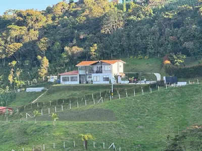 a house sitting on top of a hill at 180 degree Mountain View with good size pool in Piedra El Marcial