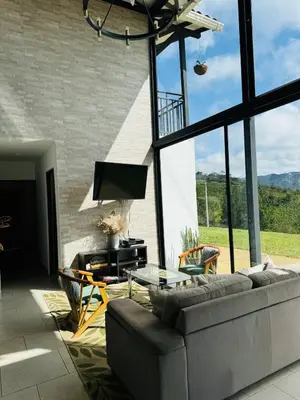 a living room with a couch and a glass table at 180 degree Mountain View with good size pool in Piedra El Marcial