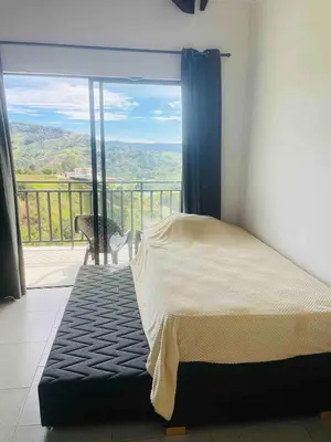 a bedroom with a bed and a balcony with a view at 180 degree Mountain View with good size pool in Piedra El Marcial