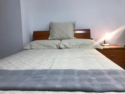 a bed with a blue and white comforter and pillows at 