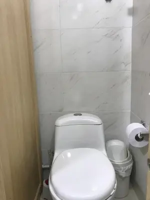 a bathroom with a white toilet and a toilet paper roll at 
