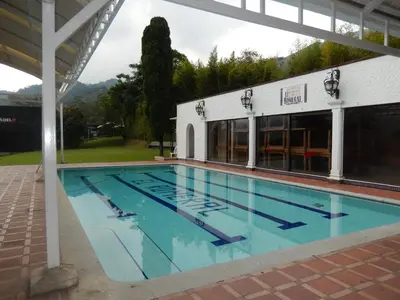 a large swimming pool in front of a building at Romeral Club Campestre in La Estrella