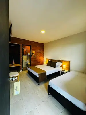 a hotel room with two beds and a television at Romeral Club Campestre in La Estrella