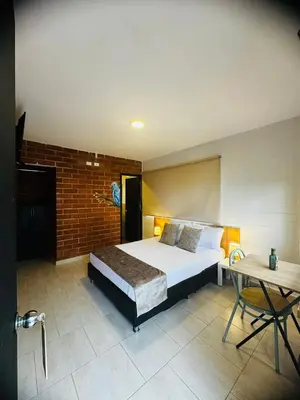 a bedroom with a bed and a table and a desk at Romeral Club Campestre in La Estrella