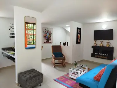 a living room with a blue couch and a tv at casa Guatape cerca al parque y malecom in Guatapé