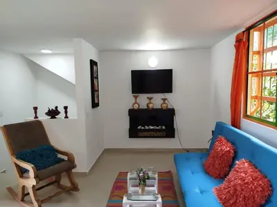 a living room with a blue couch and a tv at casa Guatape cerca al parque y malecom in Guatapé