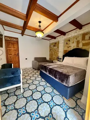 a bedroom with a bed and a couch at Hotel Boutique Sagrado Corazon in Abejorral