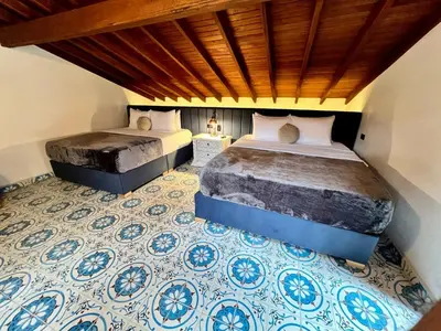 a bedroom with two beds and a tile floor at Hotel Boutique Sagrado Corazon in Abejorral