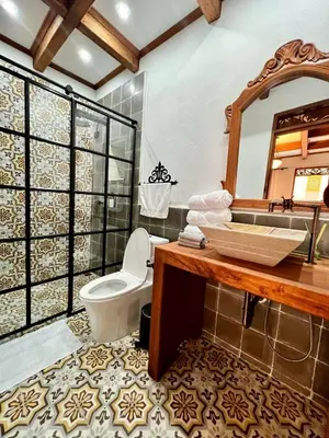 a bathroom with a sink and a toilet and a mirror at Hotel Boutique Sagrado Corazon in Abejorral