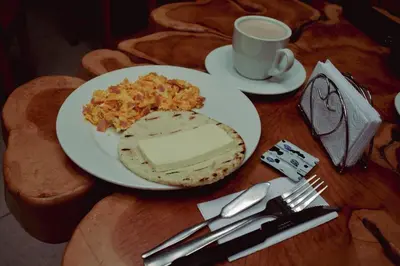 a table with a plate of food and a cup of coffee at Hotel Boutique Sagrado Corazon in Abejorral