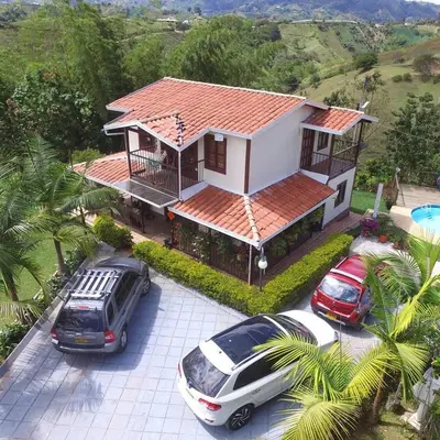 a house with two cars parked in front of it at Finca La Concordia in Chiquinquirá