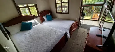 two beds in a small room with two windows at Finca La Concordia in Chiquinquirá