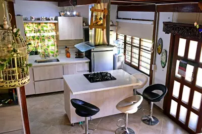 a kitchen with a stove and some stools in it at Finca La Concordia in Chiquinquirá