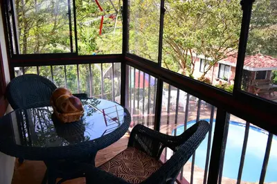 a table and chairs on a balcony with a view of a pool at Finca La Concordia in Chiquinquirá