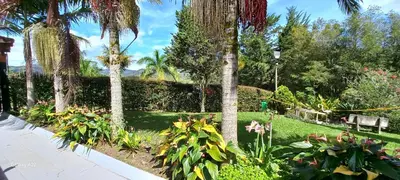 a garden with palm trees and flowers and a sidewalk at Finca La Concordia in Chiquinquirá