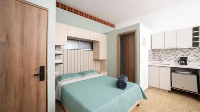 a bedroom with a bed with a cat sitting on it at Boston Coffee Lofts in Medellín