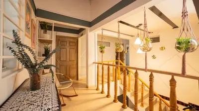a hallway with a staircase with a wooden railing and a stair case at Boston Coffee Lofts in Medellín
