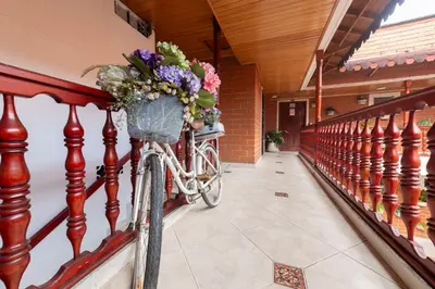 a bicycle with a basket full of flowers on a railing at Boston Coffee Lofts in Medellín