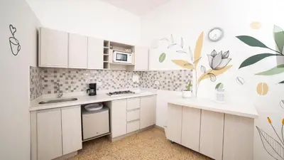 a kitchen with white cabinets and a floral wallpaper at Boston Coffee Lofts in Medellín