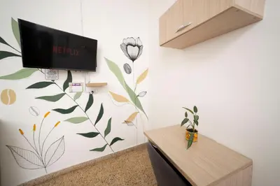a room with a tv and a flower on the wall at Boston Coffee Lofts in Medellín