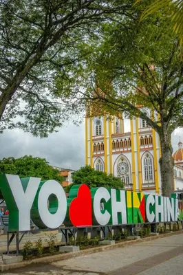 a sign in front of a yellow building at Hummingbird in Chinchiná