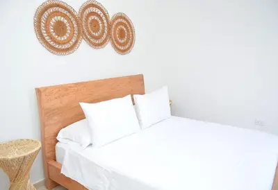 a bedroom with a white bed with white pillows at Hummingbird in Chinchiná