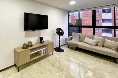 a living room with a couch and a flat screen tv at 41 Experience Laureles in style and comfort in Medellín