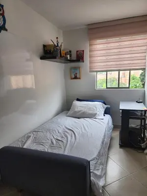 a bedroom with a bed and a desk and a window at Habitación con sofacama - apto compartido in Envigado