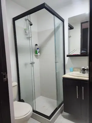 a bathroom with a shower with a toilet and a sink at Habitación con sofacama - apto compartido in Envigado
