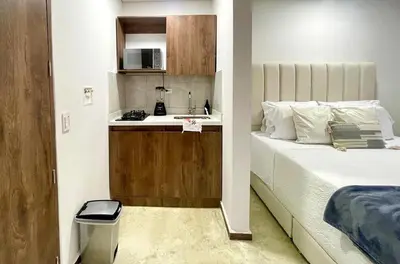 a bedroom with a bed and a sink and a kitchen at 43 Laureles Life I Modern Loft and Excellent Location in Medellín