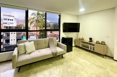 a living room with a couch and a flat screen tv at 43 Laureles Life I Modern Loft and Excellent Location in Medellín