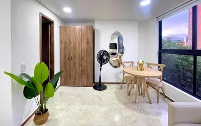 a living room with a table and a window at 43 Laureles Life I Modern Loft and Excellent Location in Medellín
