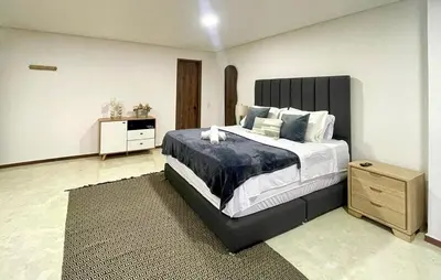 a bedroom with a large bed and a dresser at 44 Laureles I Medellín - Modern Loft - Céntrico y excelente ubicación in Medellín