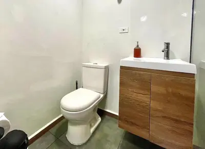 a bathroom with a white toilet and a sink at 44 Laureles I Medellín - Modern Loft - Céntrico y excelente ubicación in Medellín