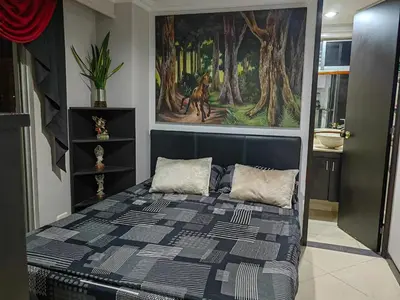 a bedroom with a bed with a painting on the wall at Edifio Barlovento in Bello