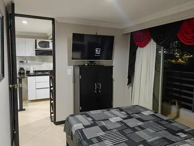 a bedroom with a bed and a flat screen tv at Edifio Barlovento in Bello