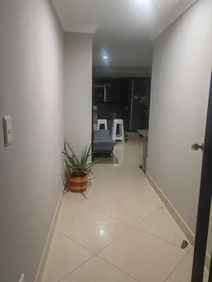 a hallway with a room with a couch and a plant at Edifio Barlovento in Bello