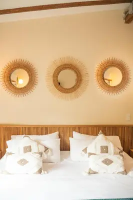 a bedroom with three mirrors above a bed at Candelaria Aparta Hotel Boutique in Medellín