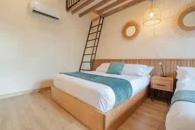 a bedroom with a bed and a ladder at Candelaria Aparta Hotel Boutique in Medellín